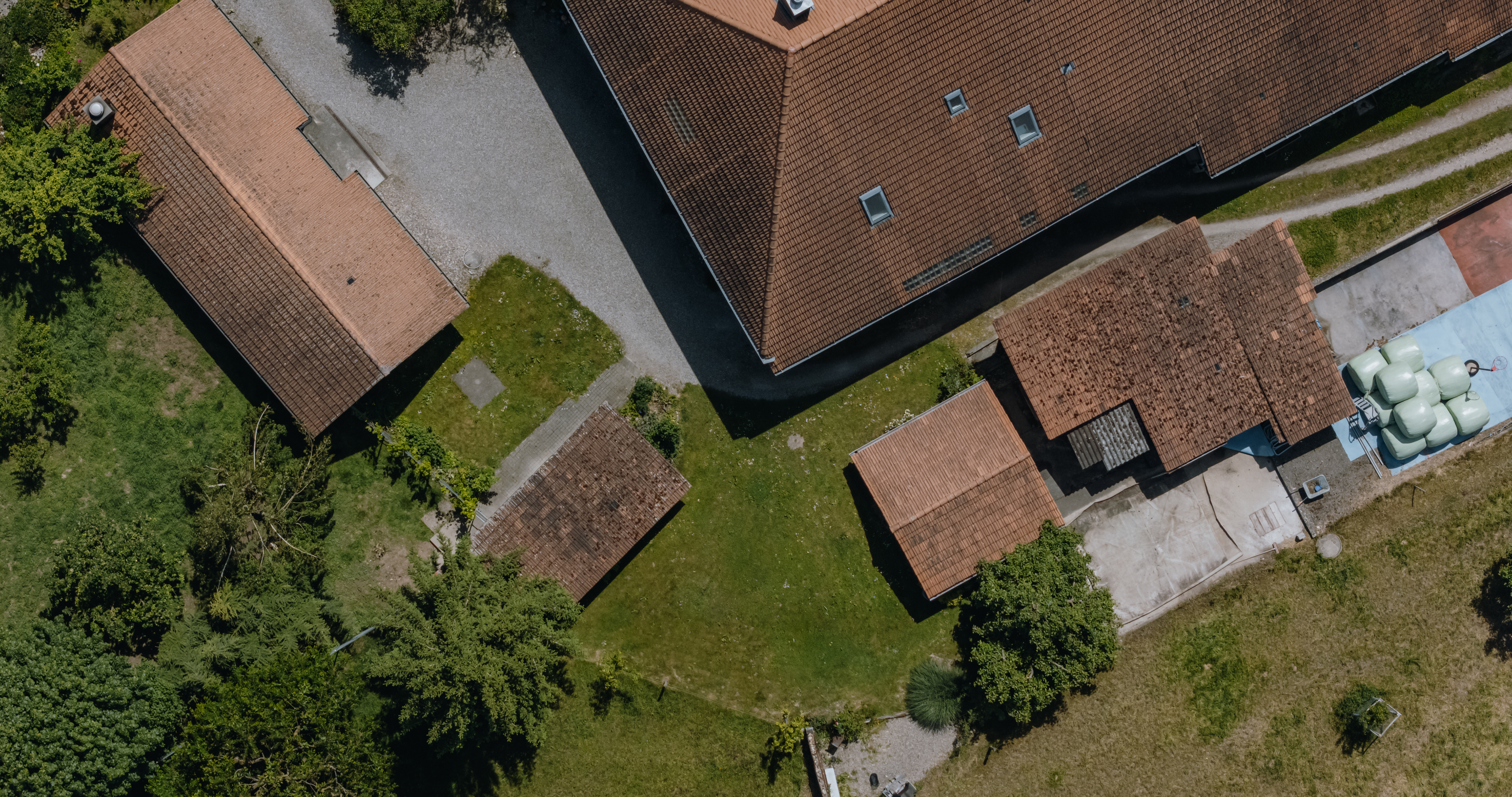 Luftaufnahme eines Gebäudekomplexes mit Grünflächen.