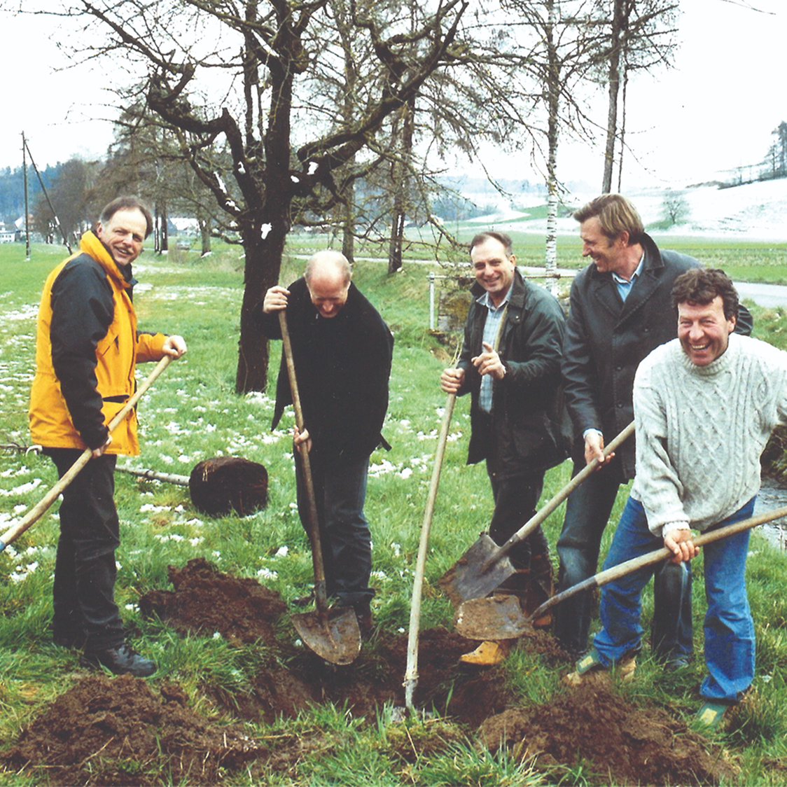 Eine Gruppe von Männern beim Graben im Freien.